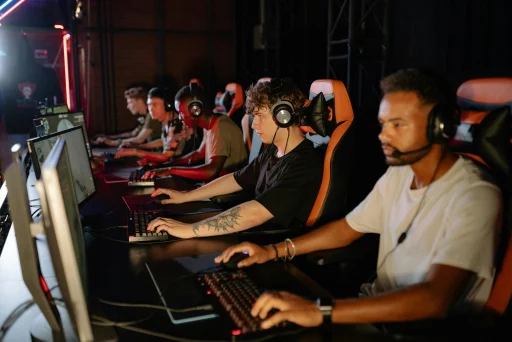Row of gaming stations with purple-lit PC towers at a partner gaming café