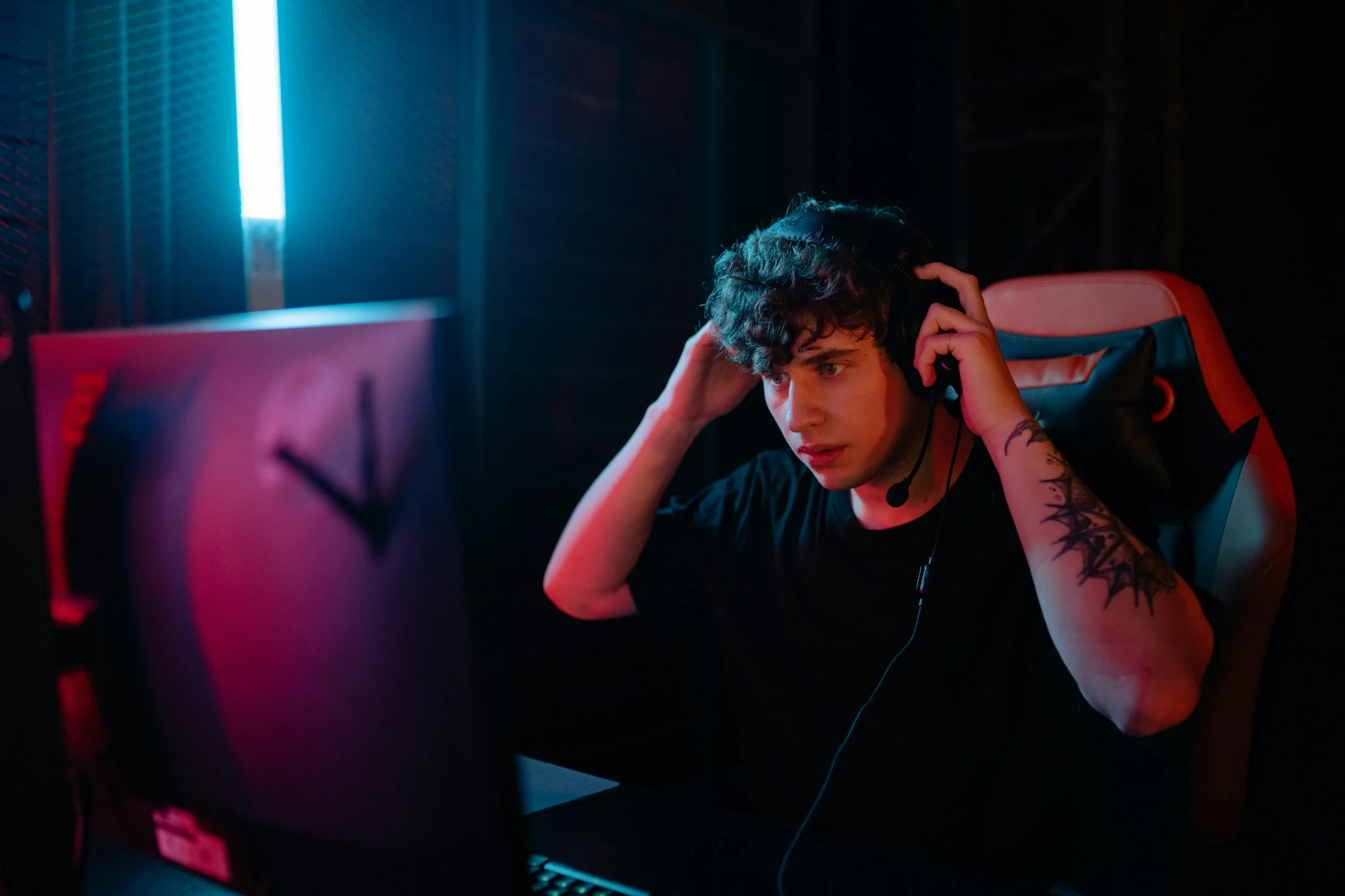 Gamer putting on a headset at a computer