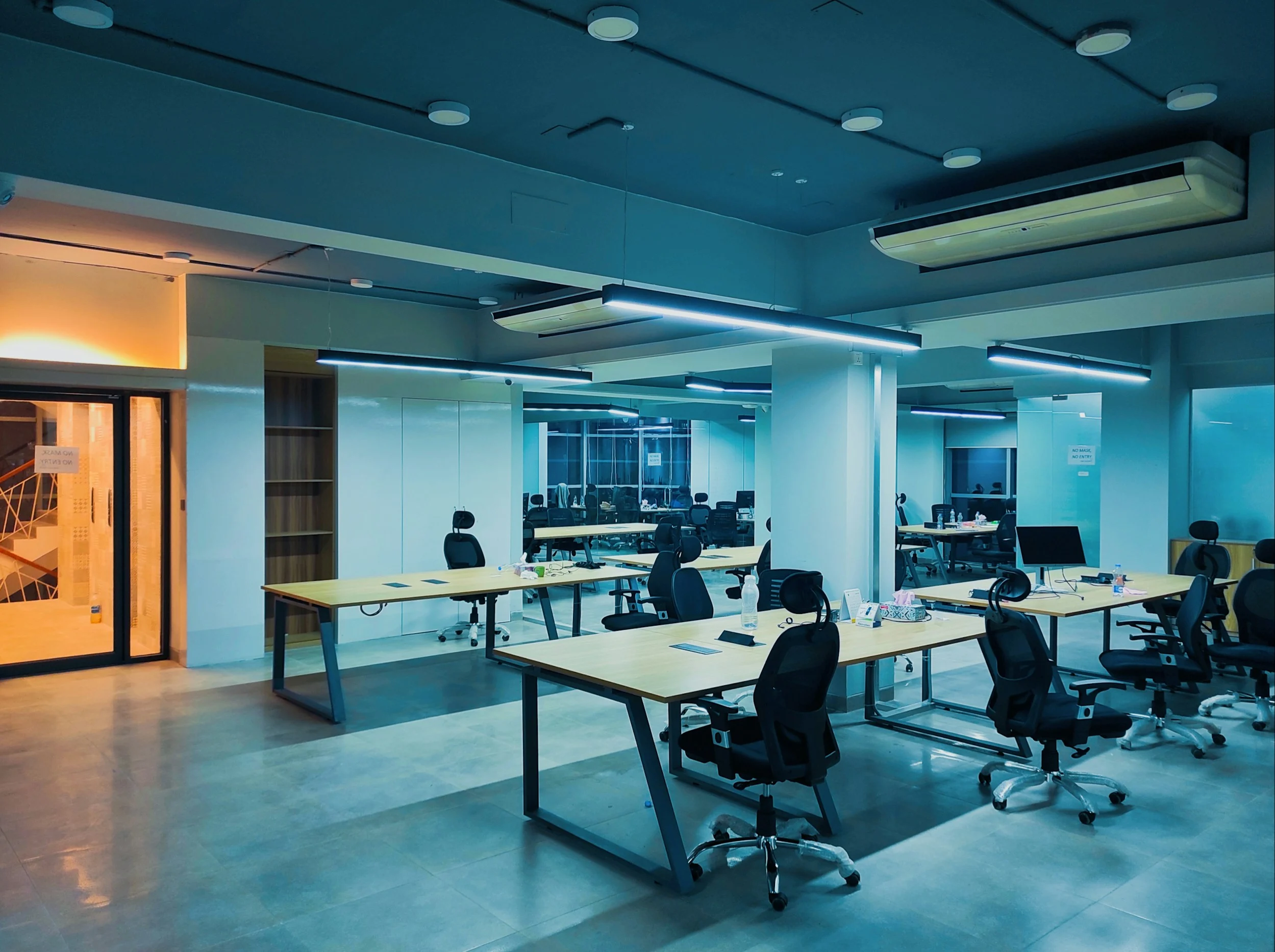 Modern purple-lit office space fitted out with desks and ergonomic chairs